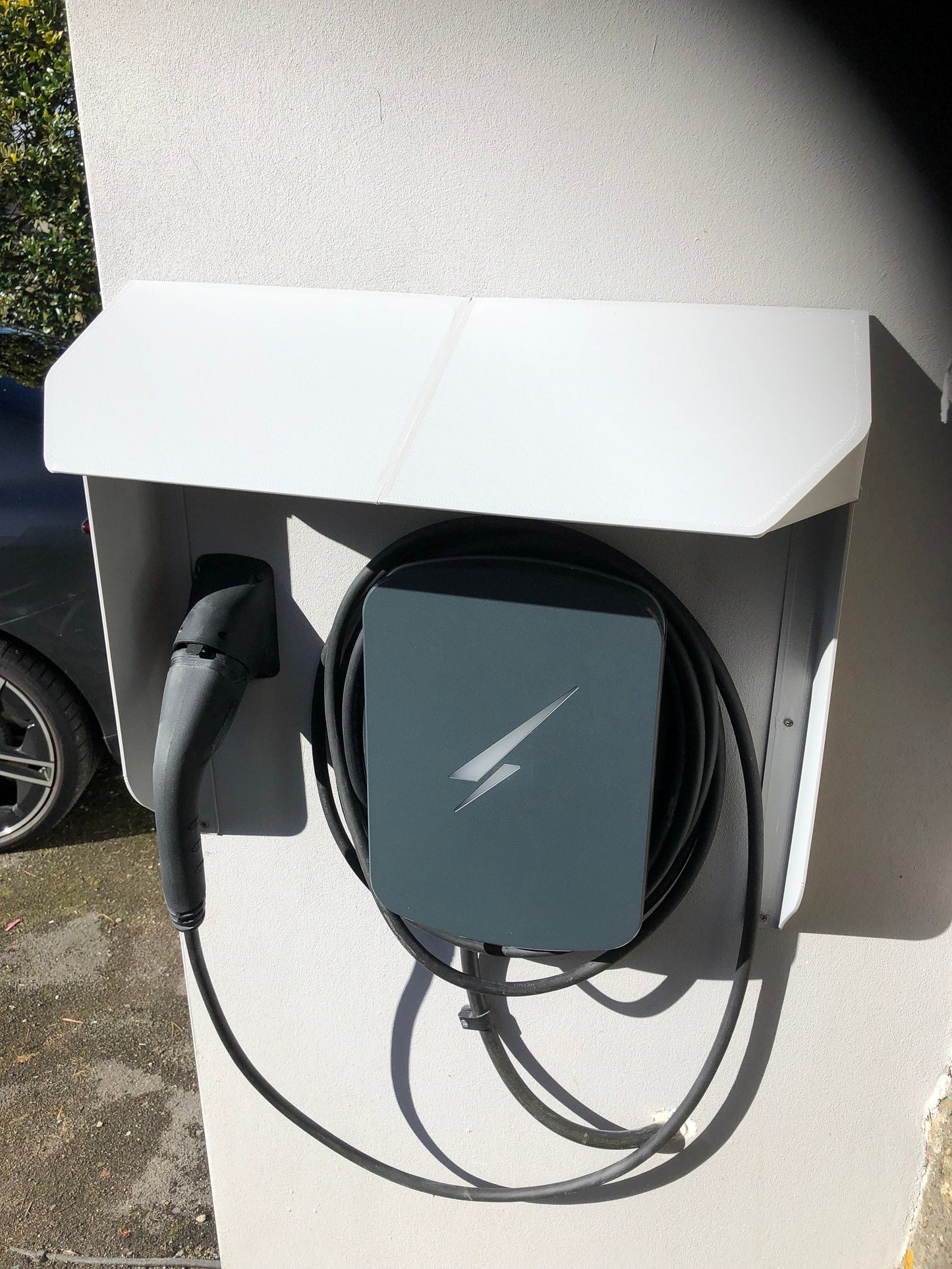 Electric vehicle charging station with a cable plugged into an electric vehicle.